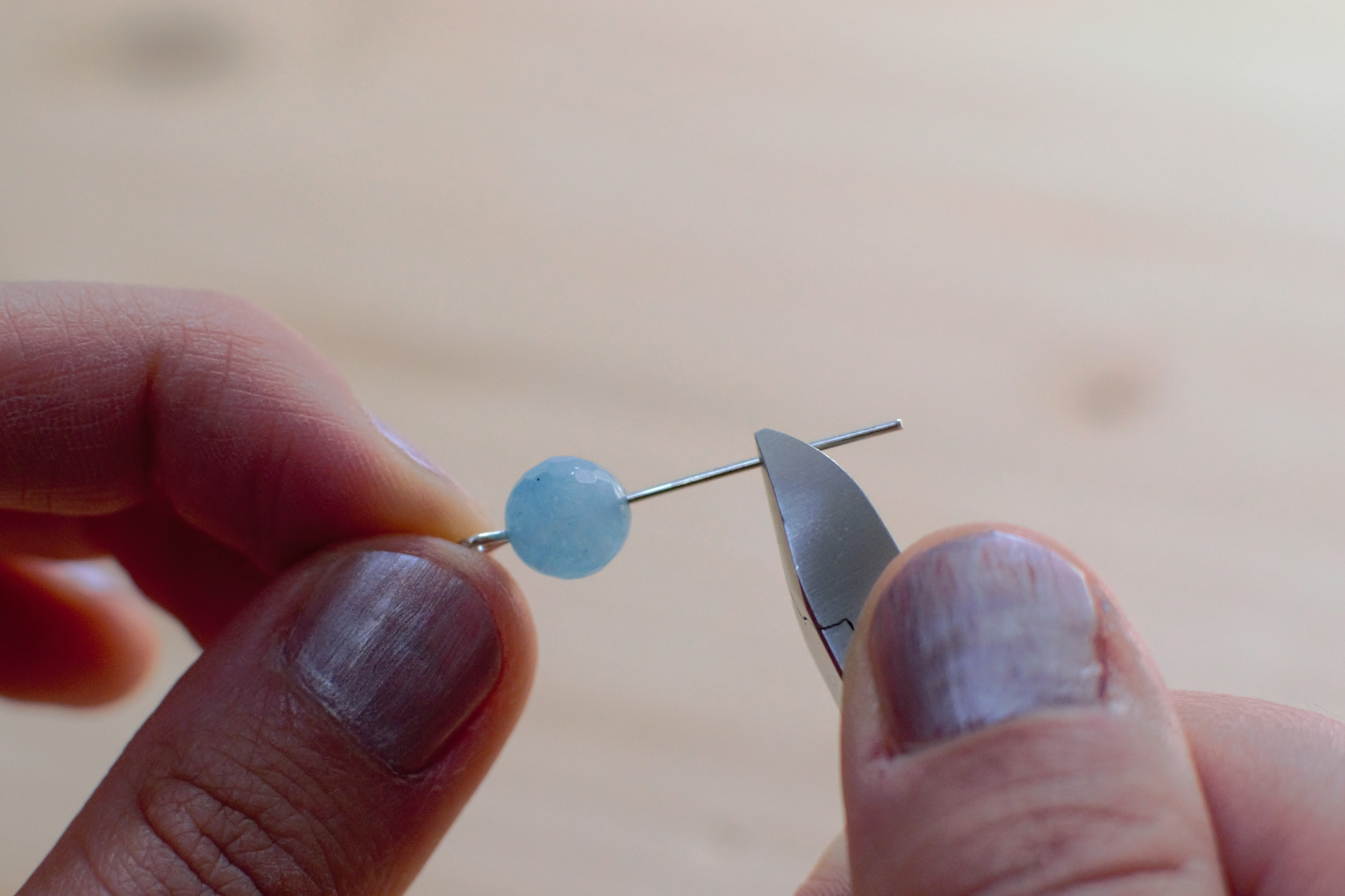 enfiler perle bleue sur le clou et le couper à 1 cm